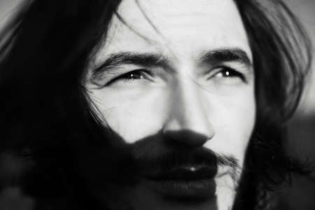 Black and white close-up portrait of young guy with long hair.の写真素材