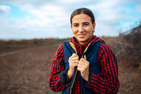 Portrait of happy young farmer woman on background of blurred field.