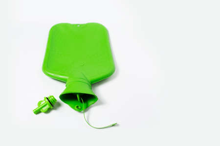 Close-up top view of green medical hot water bottle and cap, on white background with copy space.の写真素材