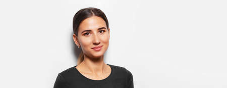Studio panoramic portrait of young cheerful girl on white background with copy space.