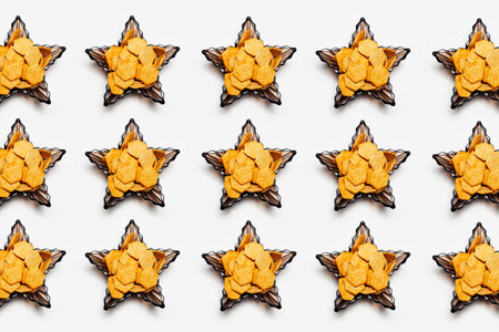 Pattern of cookies in glass bowls in shape of star on white background.