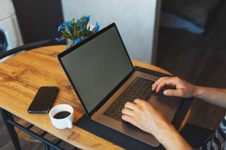 Close-up of male hands typing on keyboard of modern portable computer; man working on laptop;...
