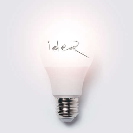 Close-up of glowing light bulb with 'idea' text against white background. Business concept.の写真素材