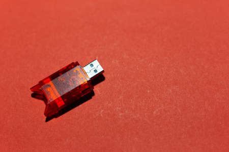 Close-up of usb flash adapter for sd card isolated on background of red color.