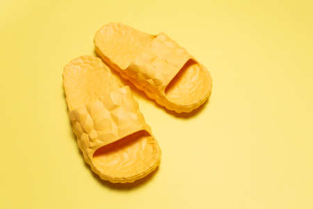 Close-up of yellow slippers on yellow background.の写真素材