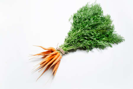 Close-up of bunch of carrots tied with a rope on white background. Top view.の写真素材