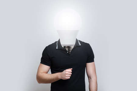 Young man with light bulb instead of head on grey background. Artwork collage.