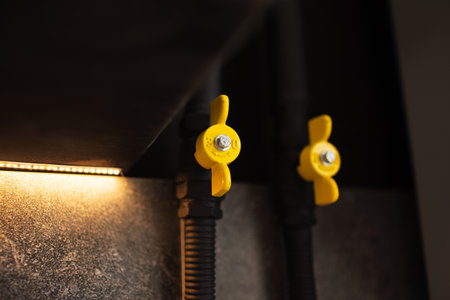 Gas cock connection between pipe and hose. Yellow and black colours.