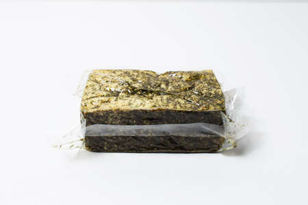 Close-up of vacuum sealed smoked tofu isolated on white background.