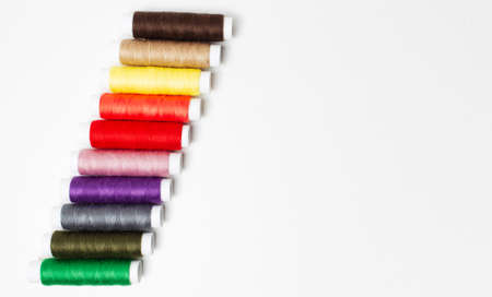 Close-up of colourful thread spools isolated on white background, copy space.