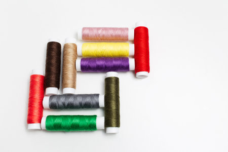 Close-up of colourful set of thread spools on white background.の写真素材