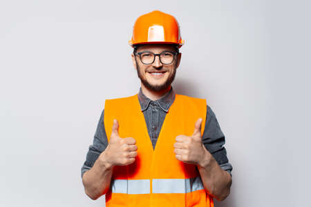 Happy construction worker showing thumbs up on white background.の写真素材