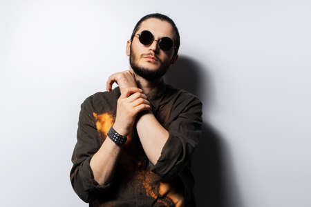 Studio portrait of young confident man on white background. Wearing sunglasses.の写真素材