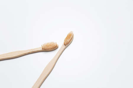 Close-up of two bamboo toothbrushes on white studio background.の写真素材