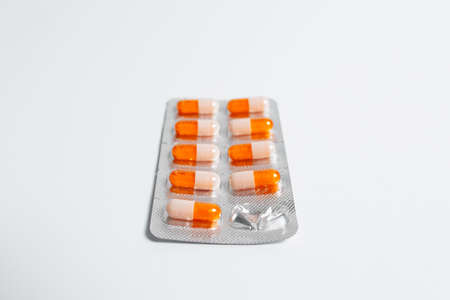 Close-up of blister with orange tablets on white background.の写真素材