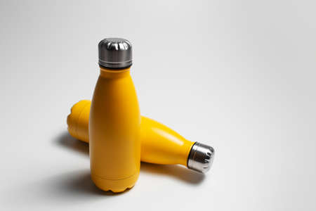 Close-up of small yellow thermo water bottles on grey background.