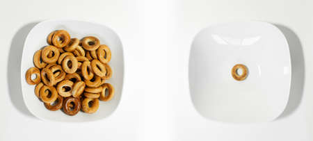 Photo collage of white bowls with small bagels, one is full, other it's empty.の写真素材