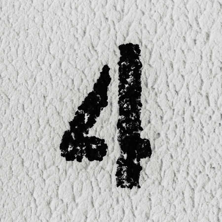 Close-up of black painted number of 4 on the grey textured wall.の写真素材