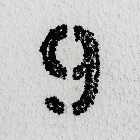 Close-up of black painted number of 9 on background of grey textured wall.の写真素材