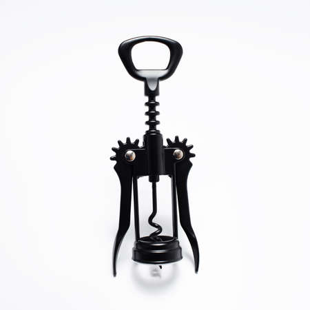 Close-up of corkscrew of black color on white studio background, wine opener.の写真素材