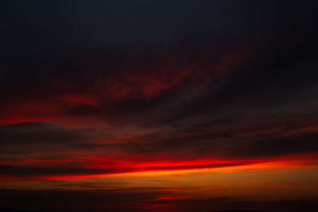 Beautiful landscape of sunset with dark colourful clouds. Natural background.の写真素材