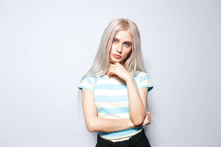 Portrait of fashionable blonde girl in striped shirt on white background.の写真素材