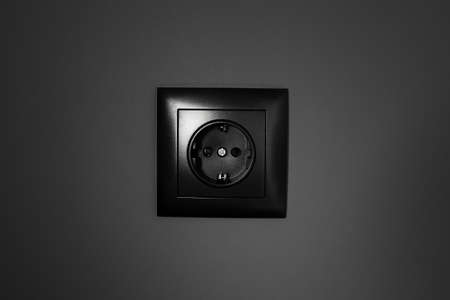 Close-up of black socket on  background of grey wall.の写真素材