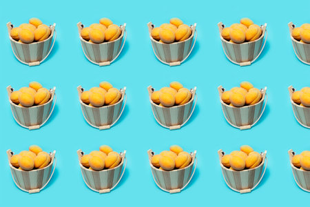 Fruit pattern of apricots in wooden bucket on background of blue colour.の写真素材