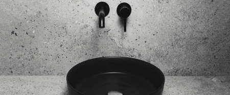 Black matte sink and wall mounted basin tap in bathroom. Panoramic banner.の写真素材