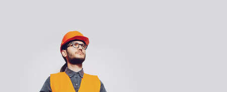 Portrait of young construction worker on white. Panoramic banner, copy space.の写真素材