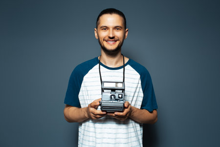 Studio portrait of young man photographer making photo with camera.の写真素材