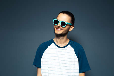 Studio portrait of young handsome smiling man, wearing sunglasses.の写真素材