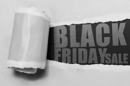 Black Friday Sale concept, text on torn paper hole of grey. Close-up view.の写真素材