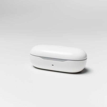 Close-up of charger case for wireless earphones on white studio background.の写真素材