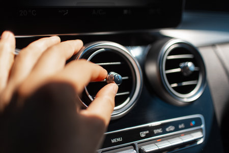 Close-up of male hand adjust the cooling system in the car.