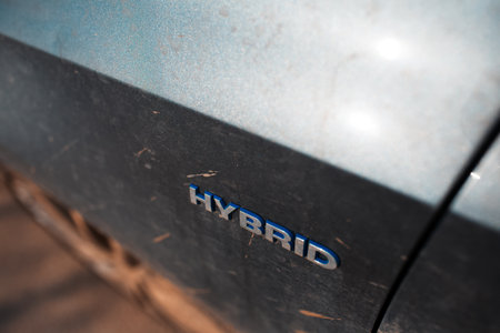 Close-up of Hybrid icon on dirty car body. Environment concept. Ecological transport.