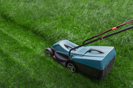 Hand lawn mower mows the green lawn in the courtyard. Top view.の写真素材