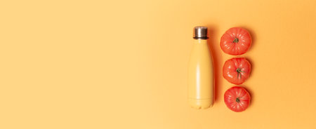 Steel thermo water bottle and three pink tomatoes on yellow panoramic background with copy space.の写真素材