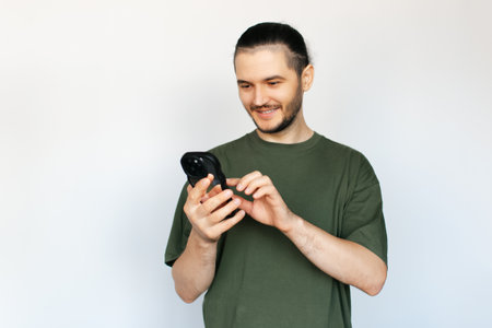 Portrait of young man, typing on smartphone, on white background.の写真素材