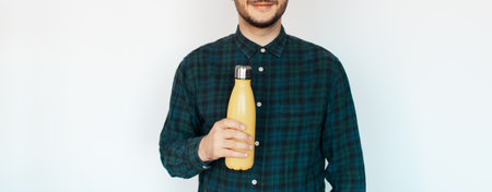 Panoramic banner. Young man with thermo bottle in hand  on white background.