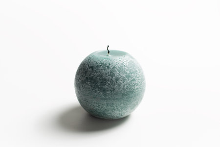Round candle pf green color on white background.の写真素材