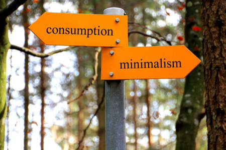 Consumption and minimalism written on a hiking signの写真素材