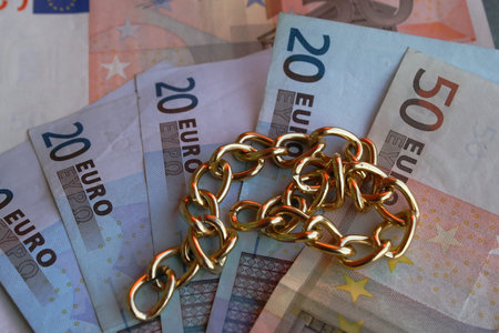 gold necklace with money in euros in the background