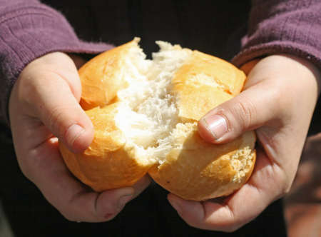 child who breaks a piece of bread with your handsの写真素材