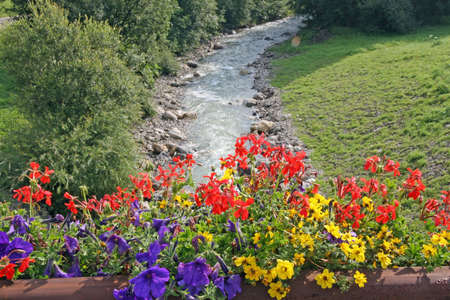 beautiful flower pots in the bridge over the rushing Creekの写真素材