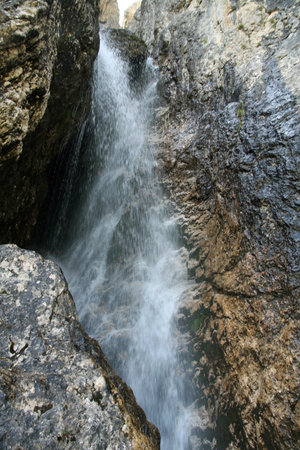 loud splashes of water from a waterfall that comes from dolomite rock