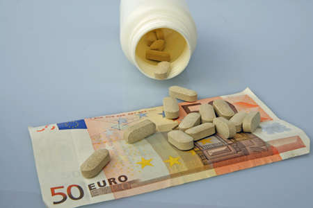 fifty euro banknote with medications scattered overの写真素材