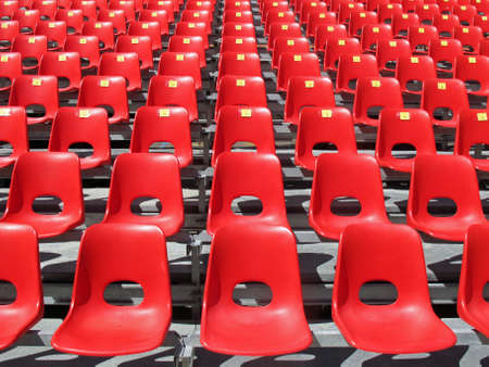 Red chairs of empty stadium but ready to accommodate the fans during the matchの写真素材