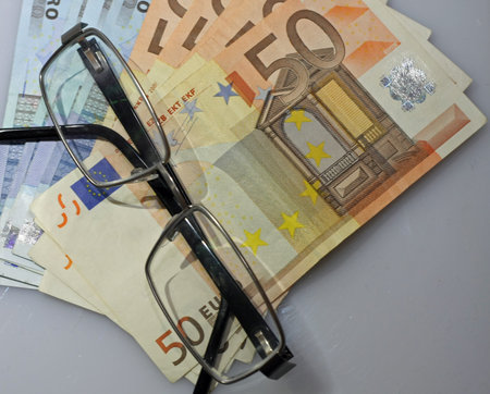 lot of money and a pair of glasses resting