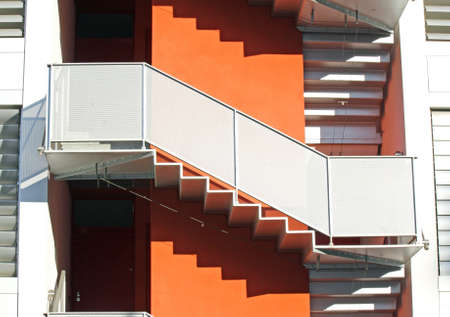external staircase of a building orange and the shadows of the stepsの写真素材